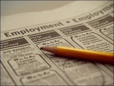 image of newspaper and someone looking for a job