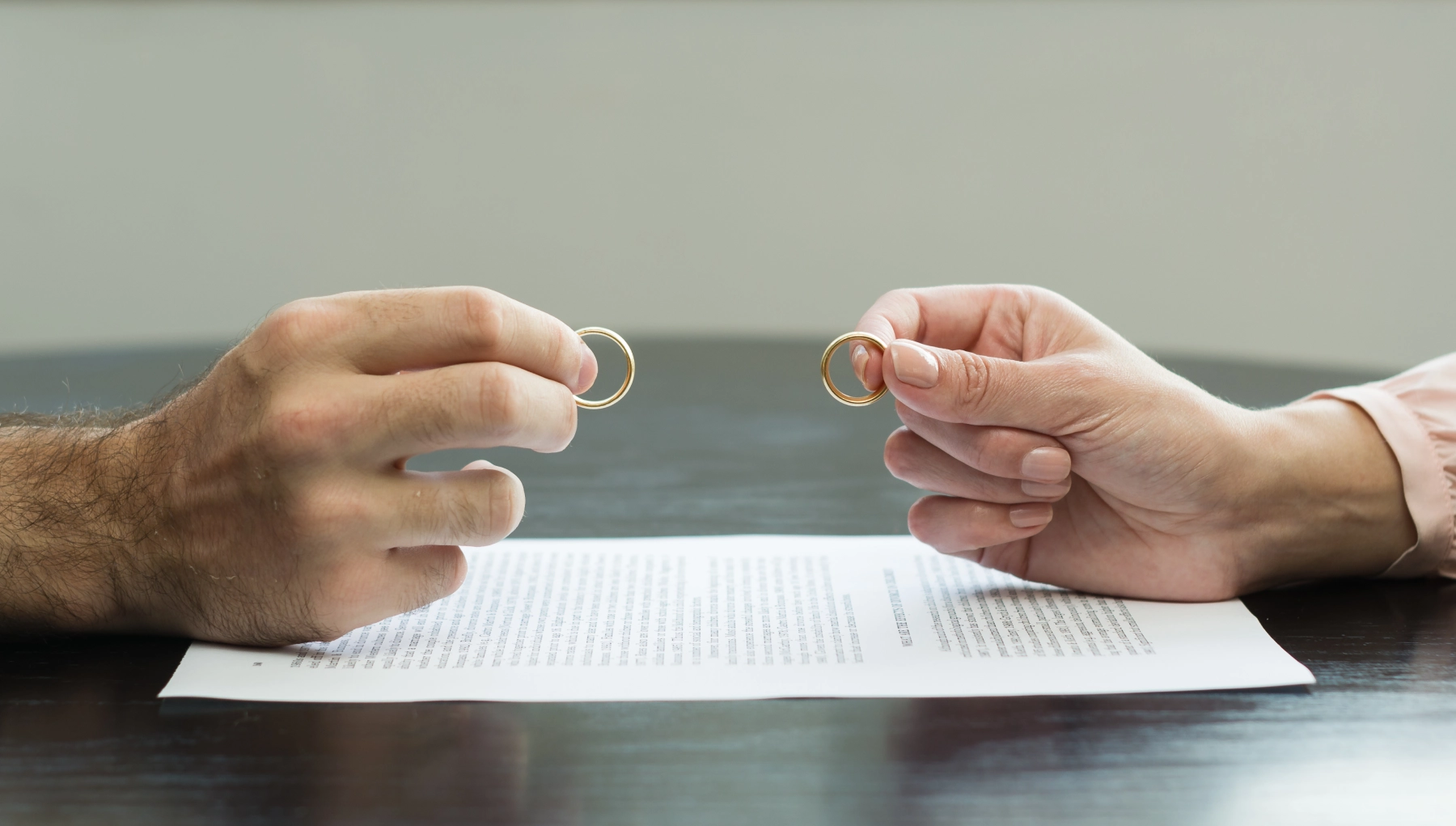 man and woman holding rings over paperwork