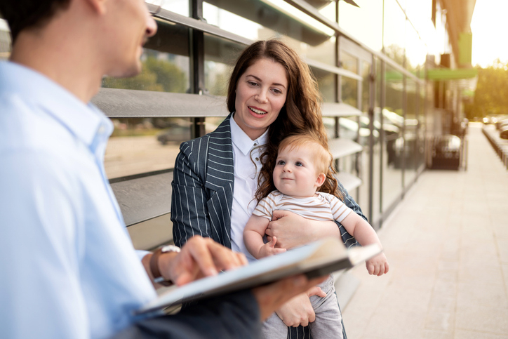 Mother holding her young child during a meeting, symbolizing the challenges of custody and visitation cases in Virginia.